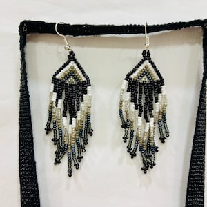Detailed close-up of matching handmade black, white, and gray seed bead fringe earrings with stainless steel hooks.