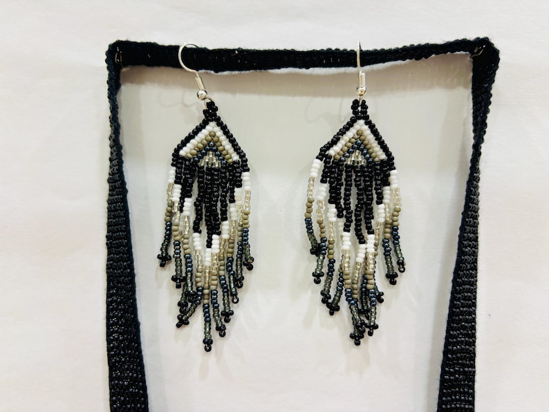 Detailed close-up of matching handmade black, white, and gray seed bead fringe earrings with stainless steel hooks.