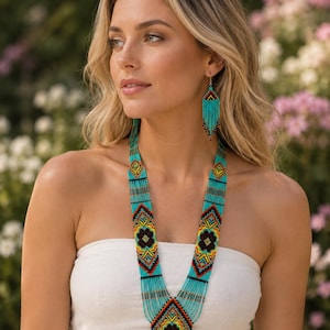 May include: A long beaded necklace and matching drop earrings featuring a vibrant geometric pattern. The jewellery set is crafted with turquoise, black, yellow, and red seed beads, arranged in diamond shapes with long, dangling fringe details.