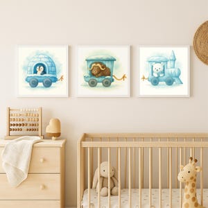 May include: Three framed watercolor prints featuring whimsical illustrations of animals in blue train cars. A penguin in an igloo, a yak, and a polar bear are depicted. The artwork is set against a soft, neutral background, suitable for a nursery or children's room.