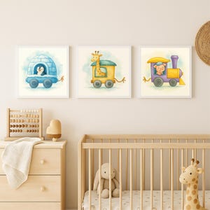 K&ouml;nnte beinhalten: Drei gerahmte Aquarelldrucke mit tierischen Charakteren. Ein Pinguin in einem iglu-f&ouml;rmigen Wagen, eine Giraffe in einem gelben Zugwagen und ein Schwein in einem lila Zugwagen. Die Drucke werden in einem Kinderzimmer ausgestellt.