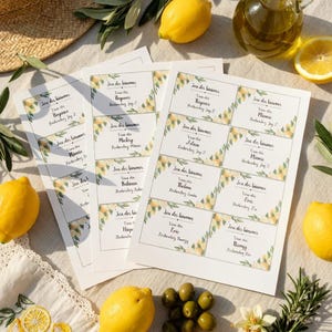 Peut inclure: Nature morte avec des citrons, des olives et de l'huile d'olive. Plusieurs cartes imprimées avec du texte sont disposées avec un chapeau de paille et des brins de romarin. La scène est posée sur une surface claire.