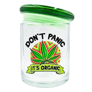 May include: A clear glass jar with a green lid. The jar features the text "DON'T PANIC" above a green cannabis leaf design with red, yellow, and green accents. Below the leaf is the text "IT'S ORGANIC".