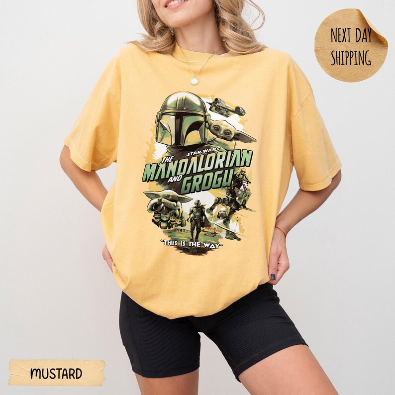 Pu&ograve; includere: T-shirt color senape con grafica di "The Mandalorian and Grogu". Il design include il casco Mandaloriano, Grogu e altri personaggi con la scritta "THIS IS THE WAY". La maglietta ha una vestibilit&agrave; ampia.