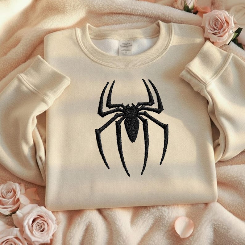 Puede incluir: Sudadera color crema con un dise&ntilde;o de ara&ntilde;a negra bordada en la parte delantera. La ara&ntilde;a est&aacute; detallada. La sudadera tiene cuello redondo y mangas largas con pu&ntilde;os acanalados.