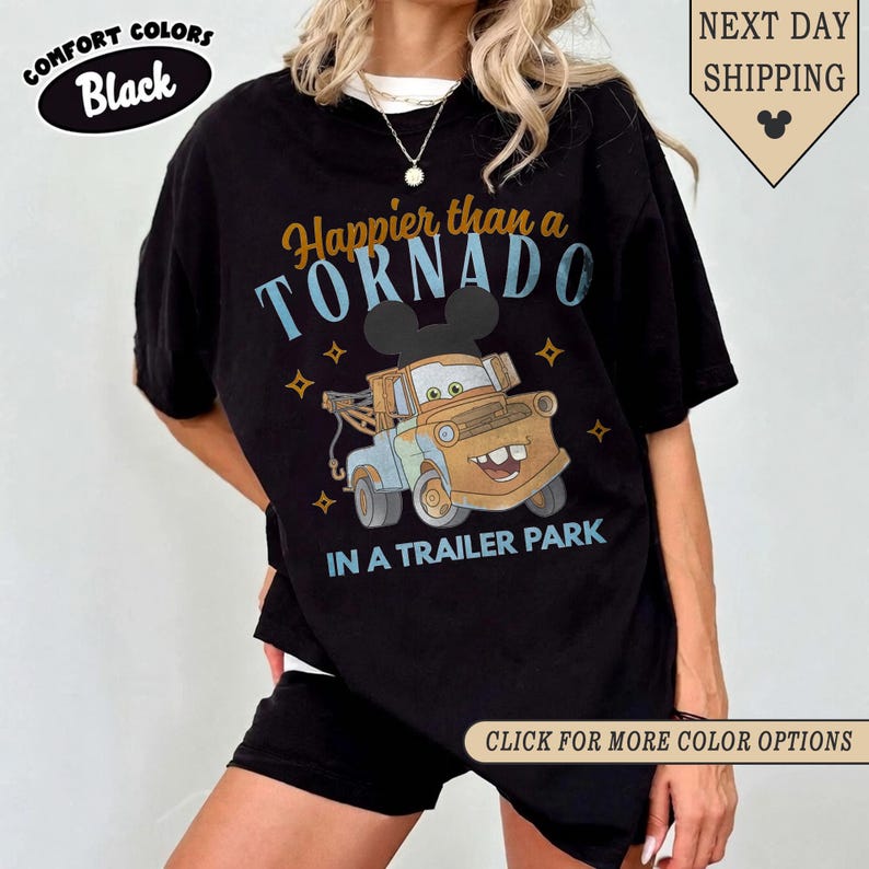 K&ouml;nnte beinhalten: Schwarzes Comfort Colors T-Shirt mit dem Text "Happier than a Tornado in a Trailer Park" und einer Cartoon-Abschleppwagen-Grafik. Das Shirt hat auch den Text "Click for more color options".