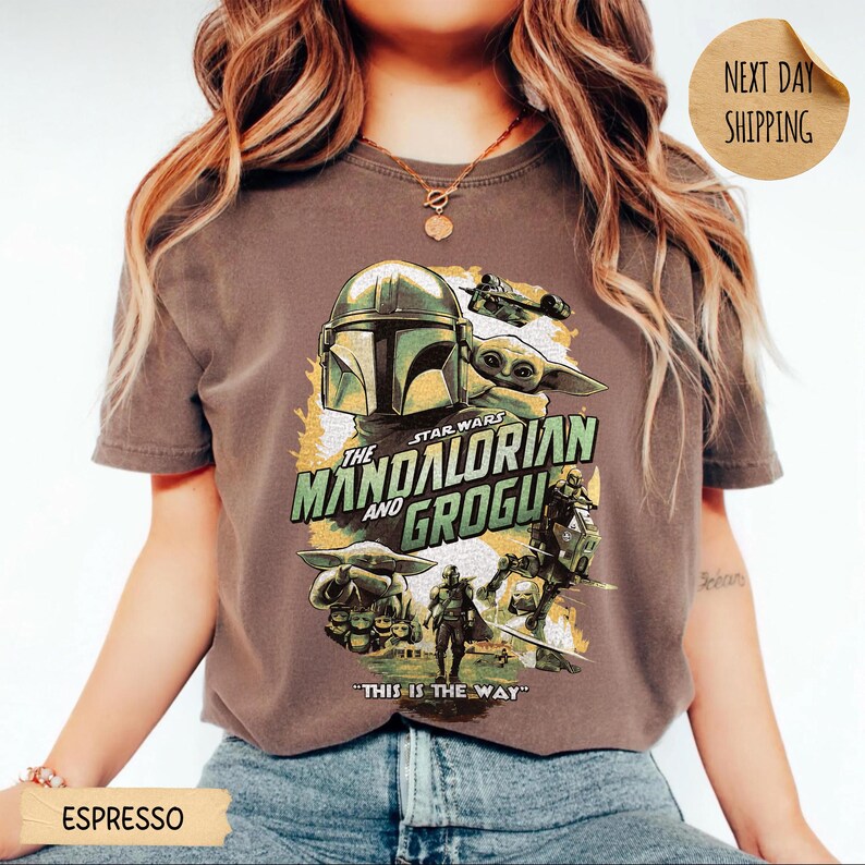 Pu&ograve; includere: T-shirt color espresso con grafica di The Mandalorian e Grogu di Star Wars. Il design include l'elmo del Mandaloriano, Grogu e la scritta "THIS IS THE WAY". La maglietta &egrave; girocollo.