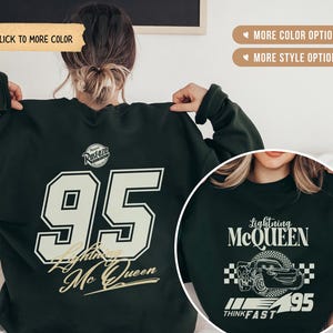 May include: Dark green sweatshirt featuring the number 95 in a white and gold font, with "Lightning McQueen" text. The back of the sweatshirt has the number 95 and "Lightning McQueen" text. The front has a Lightning McQueen graphic.