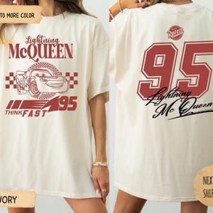May include: Ivory-colored t-shirt featuring Lightning McQueen graphics. The front displays the character's image, the text "Lightning McQueen", and "95". The back shows a large "95" and "Lightning McQueen" in red. The shirt has a relaxed fit.