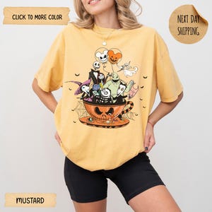 K&ouml;nnte beinhalten: Senffarbenes T-Shirt mit einem Halloween-Motiv. Das Design zeigt Charaktere aus Nightmare Before Christmas in einer Teetasse. Auf dem Shirt steht "Click to More Color" und "Next Day Shipping".