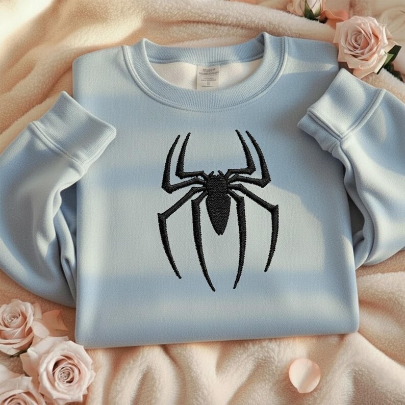 Puede incluir: Sudadera azul claro con un dise&ntilde;o de ara&ntilde;a negra bordada. La sudadera de cuello redondo est&aacute; hecha de un material suave y tiene pu&ntilde;os y dobladillo acanalados. El dise&ntilde;o de la ara&ntilde;a est&aacute; bordado en la parte delantera.