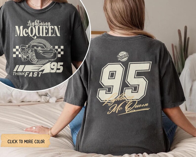 May include: Dark gray t-shirt featuring Lightning McQueen graphics. The front displays the text "Lightning McQueen" above a car illustration and "95". The back shows a large "95" and "Lightning McQueen" in a vintage style.
