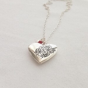 Collar con amuleto de corazón romántico y colgante protector. Hamsa y rubí. Foto familiar.