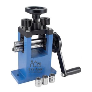 May include: A blue metal rolling mill with a black handle and gears. The machine has a hand crank and several rollers. The logo "ESS AAR INTERNATIONAL" is visible on the front. Three small metal cylinders are at the base.