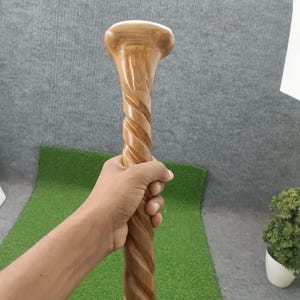 以下が含まれることがあります： 光沢のある明るい茶色の木製ステッキ。シャフトに沿って独特の螺旋状またはねじれたデザインが施され、上部には滑らかで丸みを帯びたハンドルが付いています。木目が表面全体に見え、自然な仕上がりと質感が際立っています。