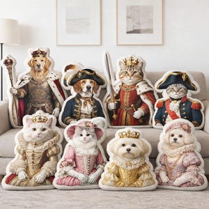 May include: A collection of plush pillows featuring regal animal portraits. The pillows depict dogs and cats dressed in royal attire, including crowns, robes, and military uniforms. The color palette includes gold, red, blue, and pink.