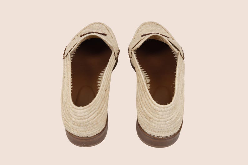 Puede incluir: Vista a&eacute;rea de dos mocasines beige tejidos con suelas y detalles marrones. Los zapatos tienen un dise&ntilde;o cl&aacute;sico sin cordones, punteras redondeadas y una correa decorativa. El interior es de color marr&oacute;n contrastante.