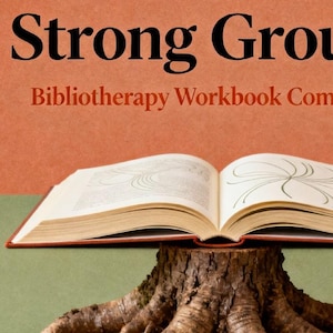 May include: An open book with the title "Strong Ground" and the subtitle "Bibliotherapy Workbook Companion" sits atop a tree stump. The book's pages display line drawings. The background is split between orange and green.
