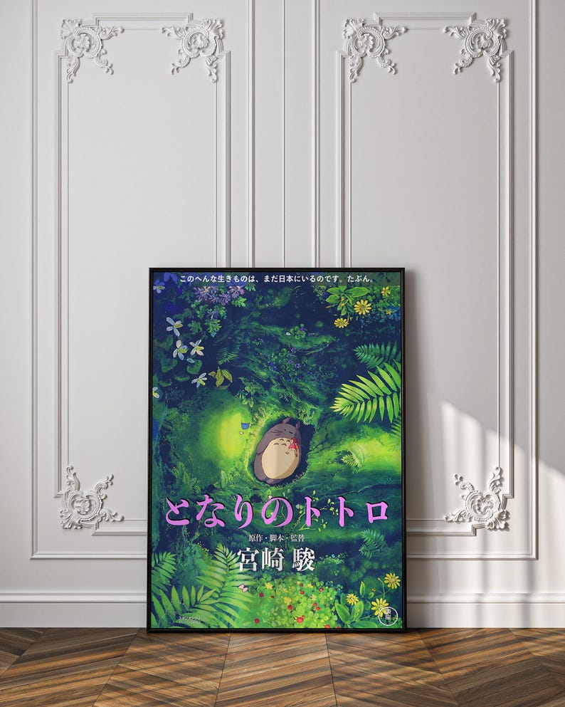 Peut inclure: Une affiche encadr&eacute;e pr&eacute;sentant une illustration vibrante du film d'animation "Mon Voisin Totoro". L'&oelig;uvre d'art repr&eacute;sente une sc&egrave;ne de for&ecirc;t avec le personnage Totoro. Du texte japonais est visible en haut et en bas de l'affiche.