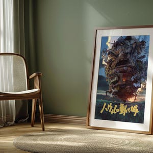 May include: Framed art print featuring a detailed illustration of a fantastical, moving castle with a fiery glow. The artwork has a brown wooden frame and is leaning against a green wall. Japanese text is visible at the bottom of the print.