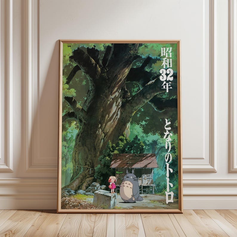 Pu&ograve; includere: Un poster incorniciato con una scena del film d'animazione, Il mio vicino Totoro. L'opera raffigura un grande albero, una bambina con un vestito rosso e Totoro, un grande spirito della foresta grigia. Testo giapponese visibile.