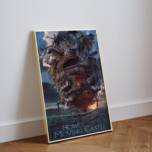 Op de afbeelding: Een ingelijste print van Howl's Moving Castle. Het kunstwerk toont het kasteel met ingewikkelde details, tegen een bewolkte lucht en een grasachtig terrein. De titel staat onderaan.