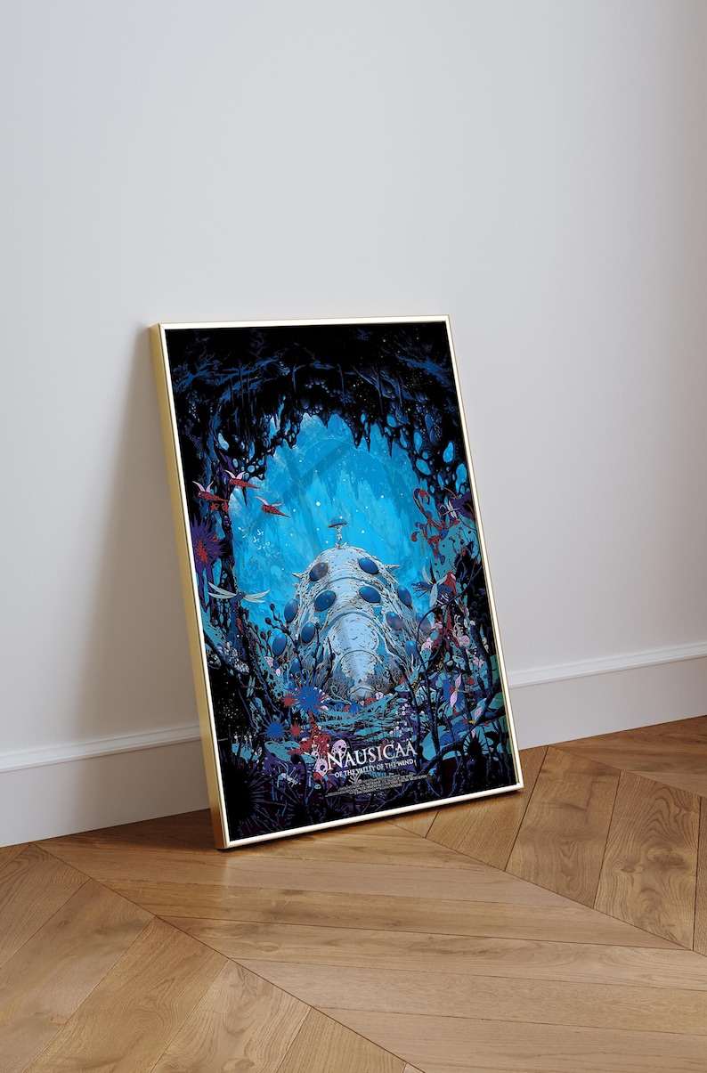 May include: Framed art print featuring a detailed illustration from the animated film "Nausica&auml; of the Valley of the Wind." The artwork showcases a futuristic vehicle in a vibrant blue and black environment, with the film's title at the bottom.