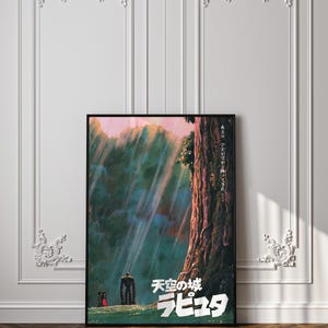 May include: A framed poster featuring artwork from the animated film "Castle in the Sky." The poster displays a vibrant landscape with a large tree, figures, and Japanese text. The color palette includes greens, blues, and pinks, with a black frame.