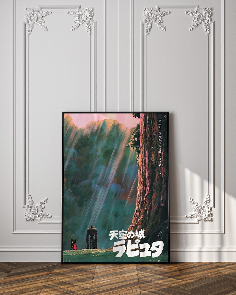 May include: A framed poster featuring artwork from the animated film "Castle in the Sky." The poster displays a vibrant landscape with a large tree, figures, and Japanese text. The color palette includes greens, blues, and pinks, with a black frame.