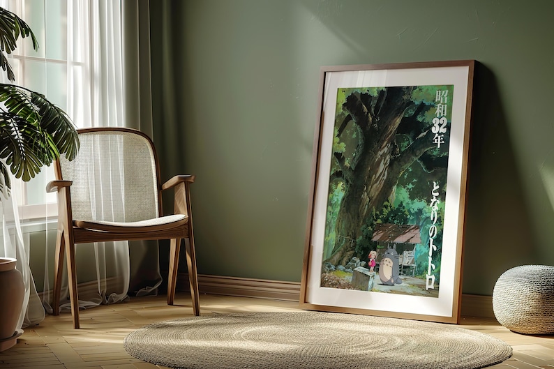 Pu&ograve; includere: Un poster incorniciato con una scena del film d'animazione "Il mio vicino Totoro". L'opera d'arte raffigura un grande albero, una piccola casa e i personaggi Totoro e Mei. Il poster &egrave; in una cornice di legno e poggia su un muro verde.