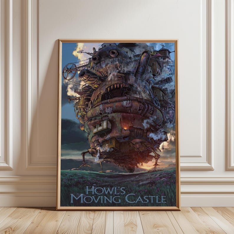 Op de afbeelding: Een ingelijste poster met de animatiefilm "Howl's Moving Castle". De afbeelding toont het kasteel met zijn mechanische details, tegen een achtergrond van een zonsonderganghemel en een grasveld. De titel staat onderaan.