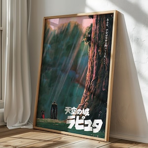 May include: Framed poster featuring artwork from the animated film "Castle in the Sky." The poster depicts a forest scene with a large tree, a robot, and a small figure. Japanese text is visible. The poster is in a wooden frame and leans against a wall.