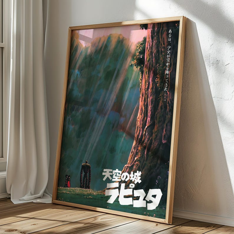 May include: Framed poster featuring artwork from the animated film "Castle in the Sky." The poster depicts a forest scene with a large tree, a robot, and a small figure. Japanese text is visible. The poster is in a wooden frame and leans against a wall.