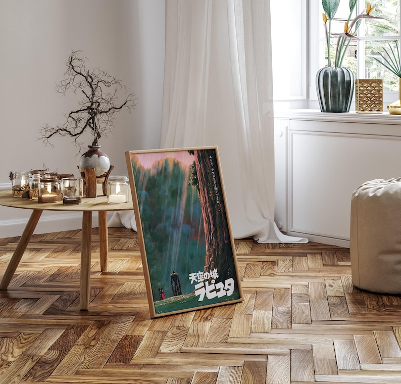 May include: A framed poster with Japanese text and a nature scene featuring a waterfall and two figures. The poster is leaning against a wall on a wooden floor. The room has a neutral color palette with a round wooden table and a vase.