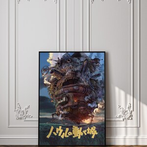 May include: Framed poster featuring a detailed illustration of a moving castle with mechanical elements, set against a cloudy sky. The castle is primarily brown and rusty, with gold Japanese text at the bottom. The poster is displayed on a white wall.