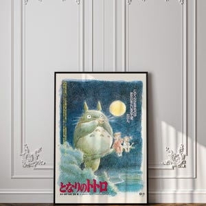 Puede incluir: P&oacute;ster enmarcado de la pel&iacute;cula de animaci&oacute;n "Mi vecino Totoro". La imagen muestra a Totoro, un gran esp&iacute;ritu del bosque gris, con dos ni&ntilde;os. El p&oacute;ster tiene texto japon&eacute;s y un fondo azul oscuro con luna llena.