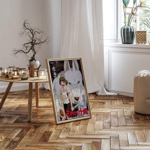May include: A framed poster featuring anime artwork. The image depicts a young person with a wolf, with Japanese text. The poster is in a wooden frame and is leaning against a wall on a hardwood floor.