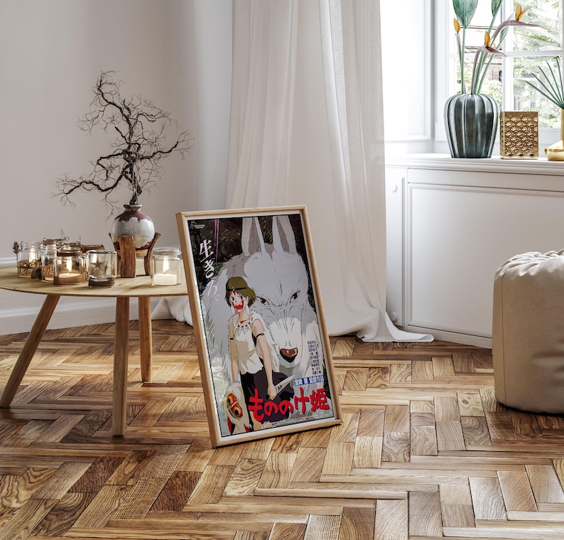 May include: A framed poster featuring anime artwork. The image depicts a young person with a wolf, with Japanese text. The poster is in a wooden frame and is leaning against a wall on a hardwood floor.