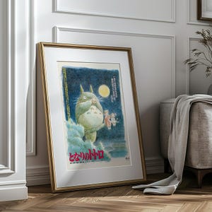 Puede incluir: Impresi&oacute;n art&iacute;stica enmarcada que representa una criatura peluda y personajes m&aacute;s peque&ntilde;os contra un cielo azul oscuro con luna llena. La obra de arte contiene texto japon&eacute;s. El marco es dorado.