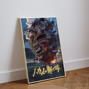 May include: Framed poster featuring a detailed illustration of a moving castle with mechanical elements, smoke, and fire. The artwork has Japanese text at the bottom and is set against a blue sky and green landscape.