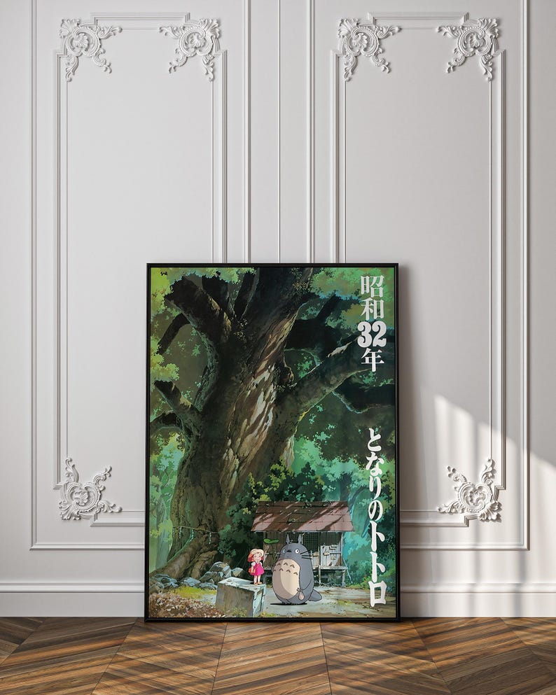 Pu&ograve; includere: Un poster incorniciato con una scena del film d'animazione "Il mio vicino Totoro". L'opera raffigura un grande albero, un piccolo rifugio e i personaggi Totoro e Mei. Testo giapponese visibile sul lato destro del poster.