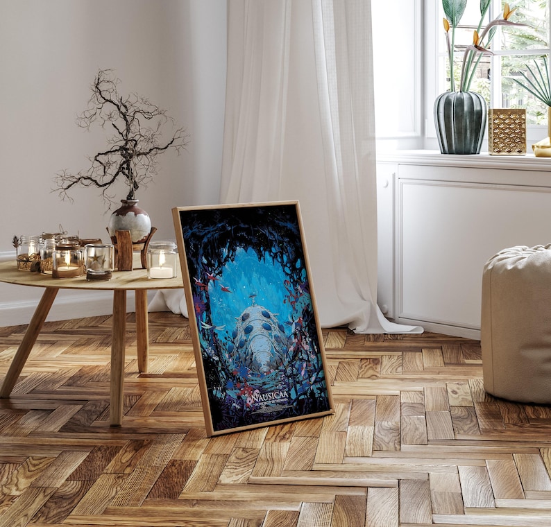 May include: A framed art print featuring a vibrant underwater scene with a large, detailed structure and the text "Nausicaa". The artwork is set against a dark, cave-like background with colorful elements. The frame is a light wood color.