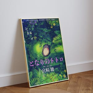 Peut inclure: Une affiche encadr&eacute;e repr&eacute;sentant une sc&egrave;ne du film d'animation "Mon Voisin Totoro". L'&oelig;uvre d'art repr&eacute;sente une sc&egrave;ne de for&ecirc;t avec le personnage Totoro. Du texte japonais est visible en bas de l'affiche.