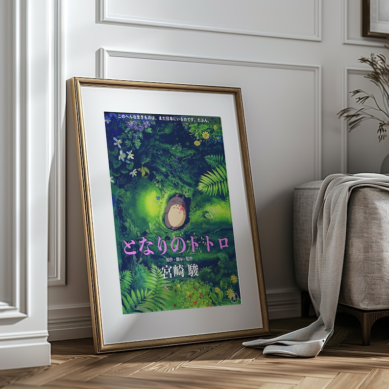 Peut inclure: Affiche encadr&eacute;e du film d'animation "Mon Voisin Totoro". L'&oelig;uvre repr&eacute;sente une sc&egrave;ne de for&ecirc;t avec le personnage Totoro. L'affiche contient du texte japonais et est dans un cadre dor&eacute;, appuy&eacute;e contre un mur.