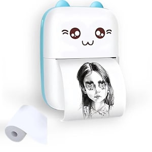 May include: A white and blue portable thermal printer with a cute cartoon face design. The printer is dispensing a black and white print of a woman's portrait. A roll of white paper is next to the printer.