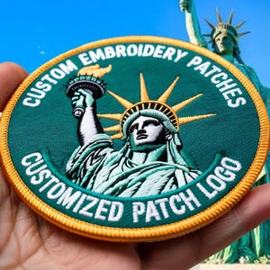 May include: Embroidered patch featuring the Statue of Liberty, with text reading "CUSTOM EMBROIDERY PATCHES" and "CUSTOMIZED PATCH LOGO". The patch is circular, with a green background, gold border, and detailed stitching.