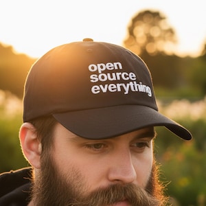 Może przedstawiać: Czarna czapka bejsbolowa z białym napisem "open source everything". Czapka ma zakrzywiony daszek i jest wykonana z wytrzymałego materiału. Klasyczny styl kapelusza, odpowiedni do codziennego użytku.