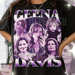 Puede incluir: Camiseta negra con un gráfico morado de Geena Davis. El gráfico incluye múltiples imágenes de Davis y el texto "GEENA DAVIS" en una fuente estilizada. La camiseta es de estilo vintage.