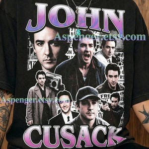 May include: A graphite-colored t-shirt featuring a collage of black and white photographic portraits of actor John Cusack. The text JOHN CUSACK appears in a purple and white gradient font at the top and bottom. The shirt includes the text Aspenger.etsy.com.