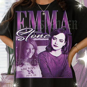 May include: Black t-shirt featuring a purple graphic of Emma Stone with the text "EMMA Stone" in a vintage style. The design includes two images of Emma Stone and the text "Ojai North Phys. Ed."